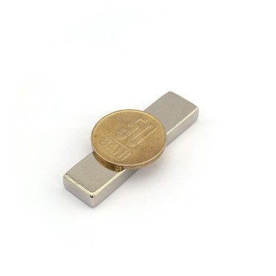 Magnet neodim bloc 50 x 13 x 6 NiCuNi N42H cu moneda de 50 bani peste